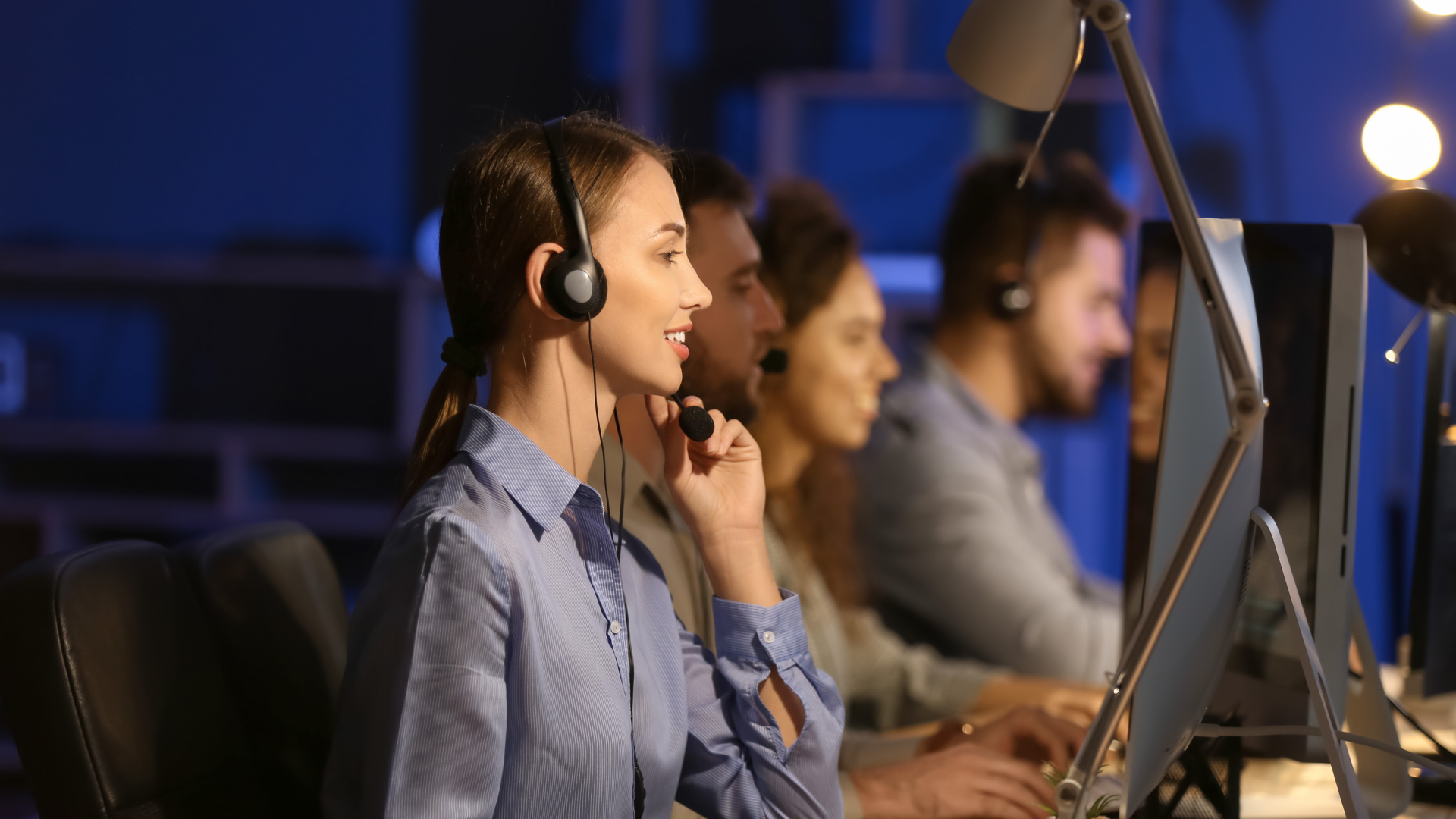 Customer support agents wearing headsets and working in a modern contact center.